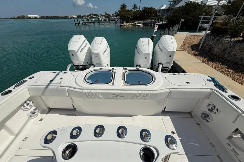  Yacht Photos Pics 2023 Invincible 46 Catamaran with four Mercury engines docked by turquoise water.