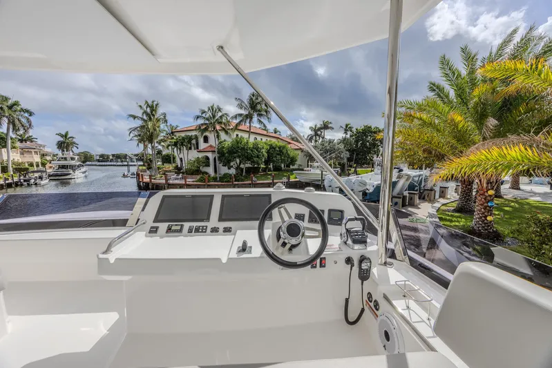  Yacht Photos Pics 2024 Leopard 53 Powercat helm with waterfront view, palm trees, and luxury homes.