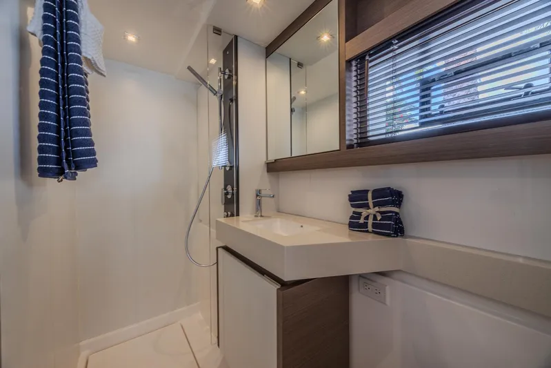  Yacht Photos Pics 2024 Leopard 53 Powercat bathroom with modern fixtures and striped towels.