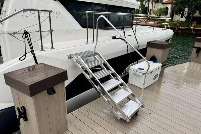  Yacht Photos Pics 2024 Leopard 53 Powercat docked with boarding ladder and cooler on deck.