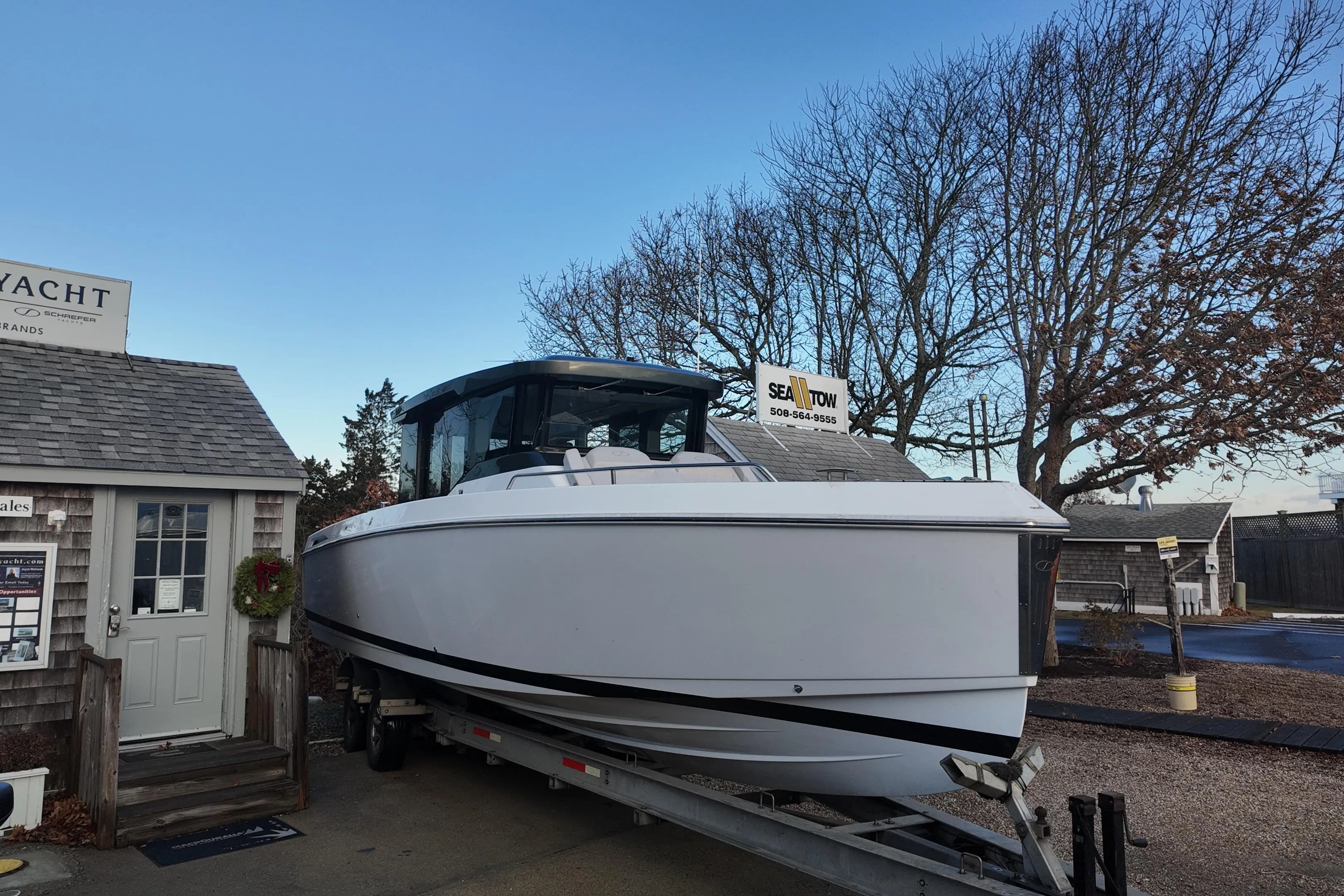2024 Schaefer V33 yacht on trailer near a yacht sales office, clear sky background.