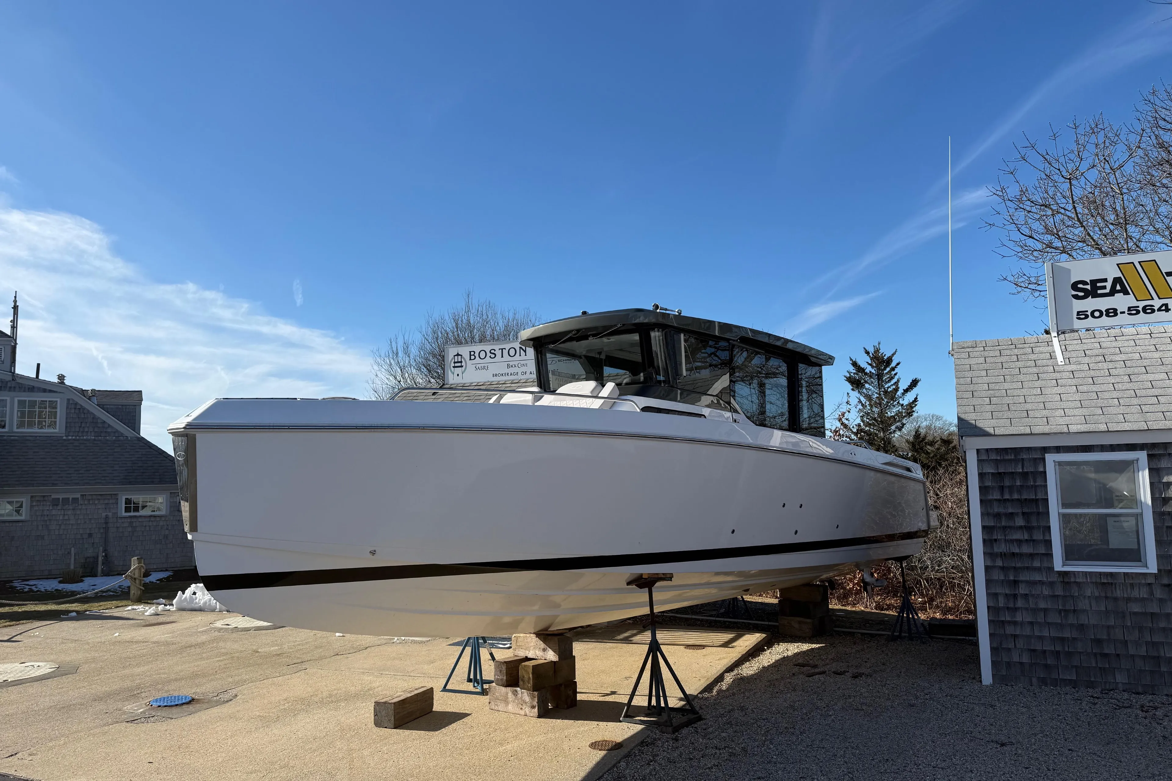 2024 Schaefer V33 boat on stands, clear sky, near a building.