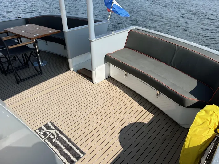  Yacht Photos Pics Deck of 2013 Vripack Utopia 58 yacht with seating and table, overlooking water.