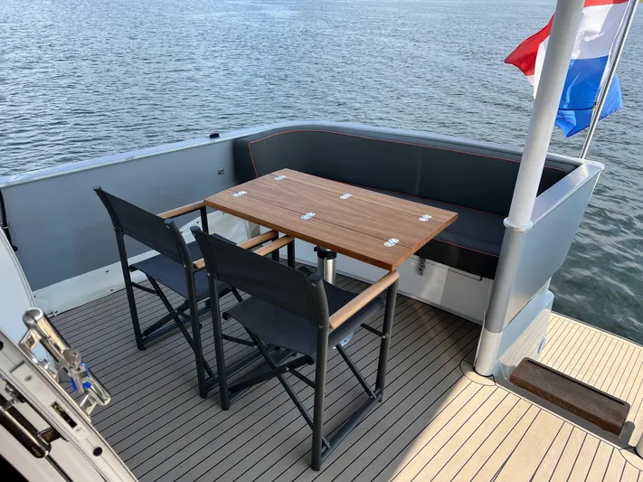  Yacht Photos Pics Deck of 2013 Vripack Utopia 58 yacht with table and chairs, overlooking water.