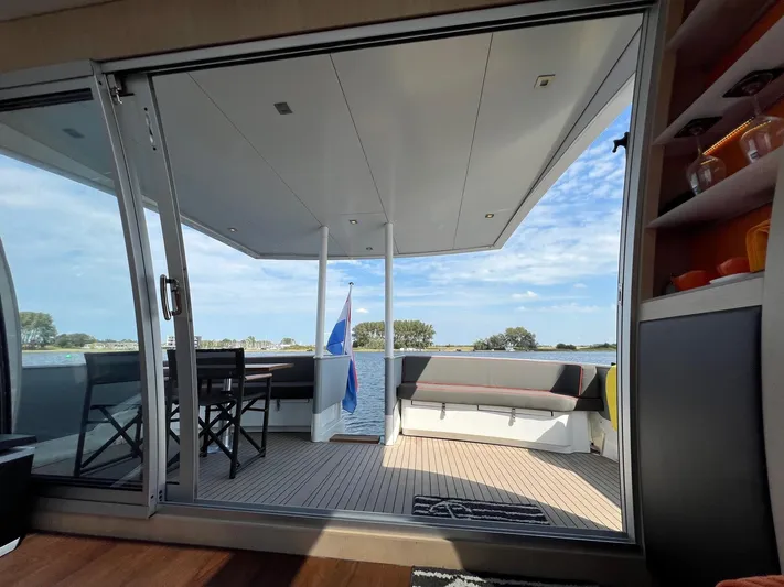  Yacht Photos Pics Luxurious Vripack Utopia 58 yacht deck with seating, table, and scenic water view.