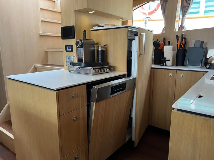  Yacht Photos Pics Modern kitchen interior of Vripack Utopia 58 yacht, featuring wooden cabinetry and built-in appliances.