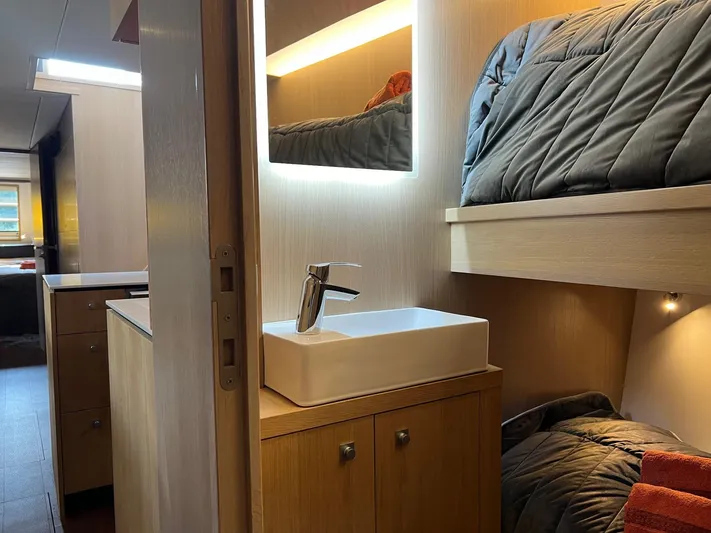  Yacht Photos Pics Modern interior of 2013 Vripack Utopia 58 yacht with bunk beds and sleek bathroom sink.