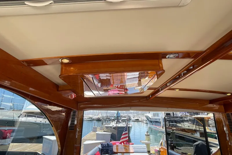White Sauce Yacht Photos Pics Interior view of 2017 Hinckley Talaria 43 Motoryacht with polished wood and marina backdrop.