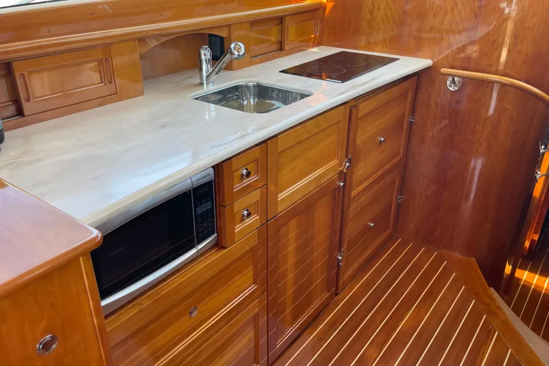 White Sauce Yacht Photos Pics Luxurious 2017 Hinckley Talaria 43 Motoryacht kitchen with wood cabinetry and modern appliances.