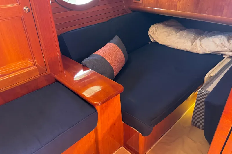 White Sauce Yacht Photos Pics Cozy interior of 2017 Hinckley Talaria 43 Motoryacht with wooden finish and navy cushions.