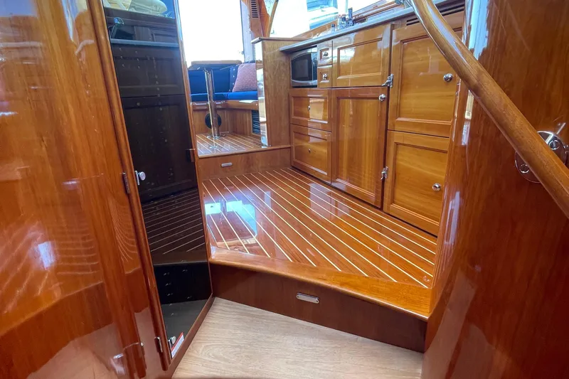 White Sauce Yacht Photos Pics Luxurious wooden interior of 2017 Hinckley Talaria 43 Motoryacht, showcasing polished cabinetry and flooring.