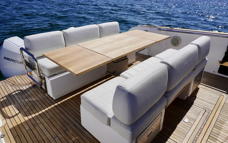  Yacht Photos Pics Luxury seating area on 2020 Pardo Yachts 38, featuring elegant wooden table and cushioned benches.