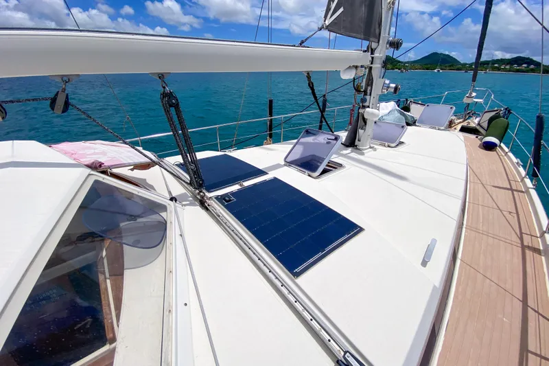  Yacht Photos Pics Sailboat deck with solar panels, Amel Super Maramu 1991, on clear blue water.