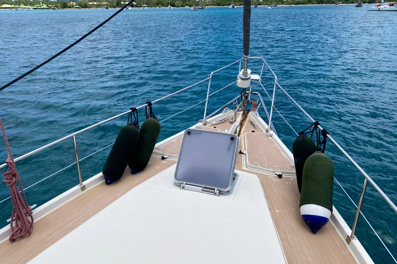  Yacht Photos Pics Bow of 1991 Amel Super Maramu yacht on calm blue water.