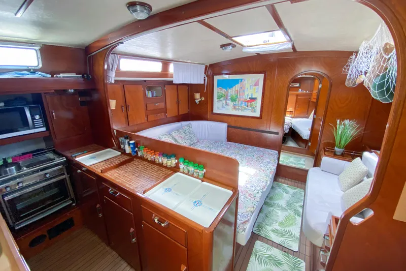  Yacht Photos Pics Interior of 1991 Amel Super Maramu yacht with kitchen, bed, and cozy seating area.