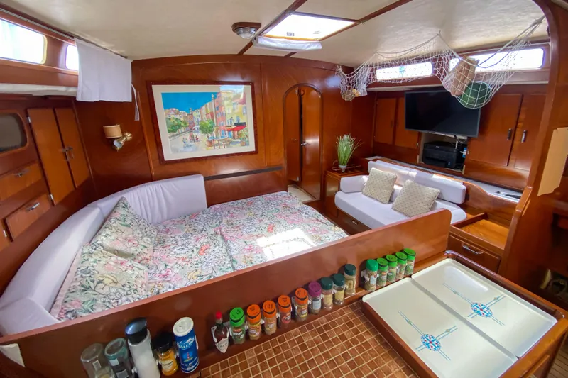 Yacht Photos Pics Interior of 1991 Amel Super Maramu yacht with cozy bed, spices, and seating area.