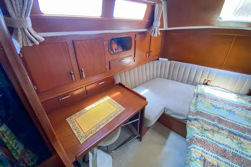  Yacht Photos Pics Cozy cabin interior of 1991 Amel Super Maramu sailboat with wooden desk and seating area.