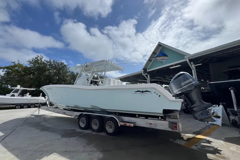  Yacht Photos Pics 2019 Invincible 39 Open Fisherman boat on trailer, parked outdoors under cloudy sky.