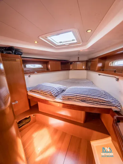  Yacht Photos Pics Interior cabin of 2011 Beneteau Oceanis 46 yacht with cozy bed and wooden finish.