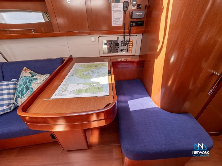  Yacht Photos Pics Interior of 2011 Beneteau Oceanis 46 sailboat with navigation table and seating area.