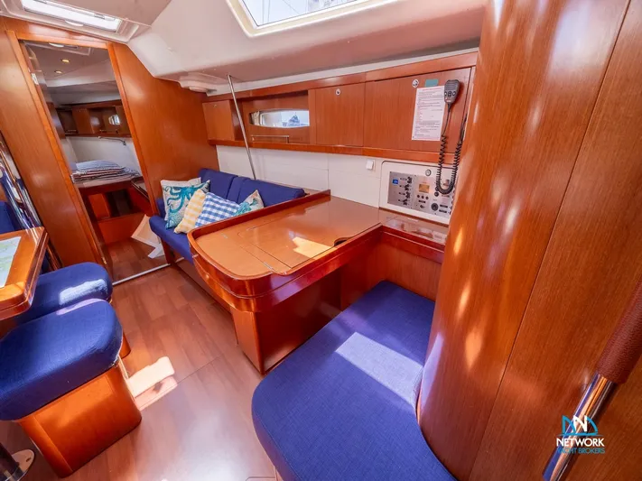  Yacht Photos Pics Interior of 2011 Beneteau Oceanis 46 sailboat with wood finish and blue seating.