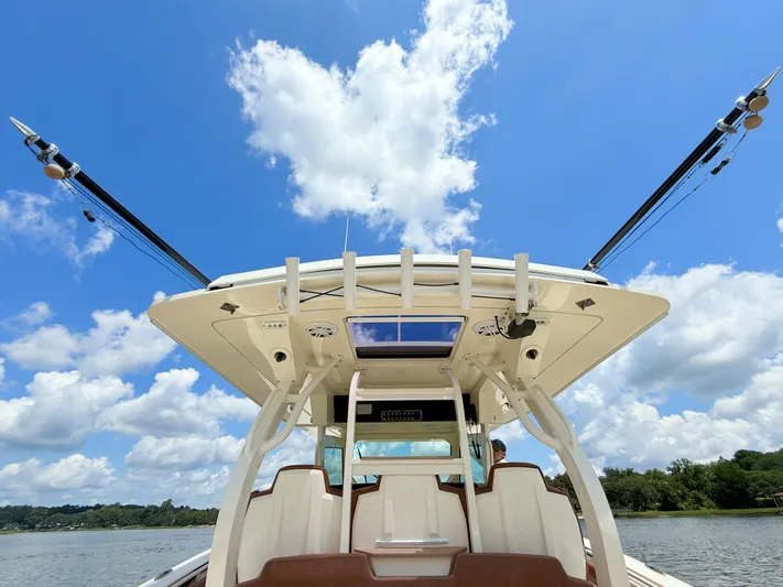 Wild Horses Yacht Photos Pics 2020 Scout 380 LXF boat with fishing rods, under a clear blue sky.