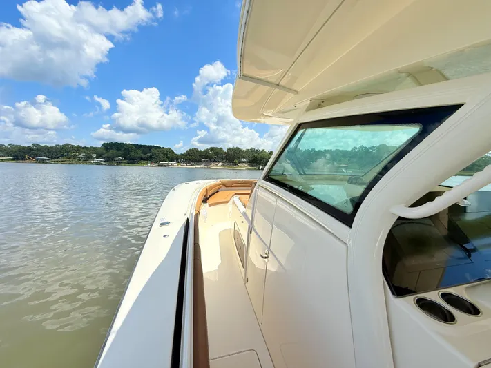 Wild Horses Yacht Photos Pics 2020 Scout 380 LXF boat on calm water under a blue sky with clouds.