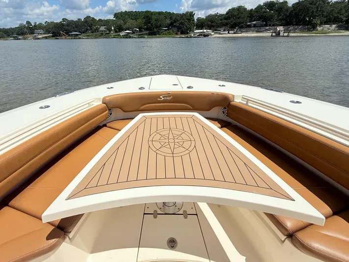 Wild Horses Yacht Photos Pics 2020 Scout 380 LXF boat interior with tan seating and wooden table on a lake.