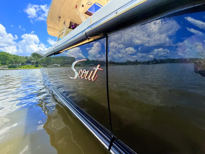 Wild Horses Yacht Photos Pics 2020 Scout 380 LXF boat on water, reflecting blue sky and clouds.