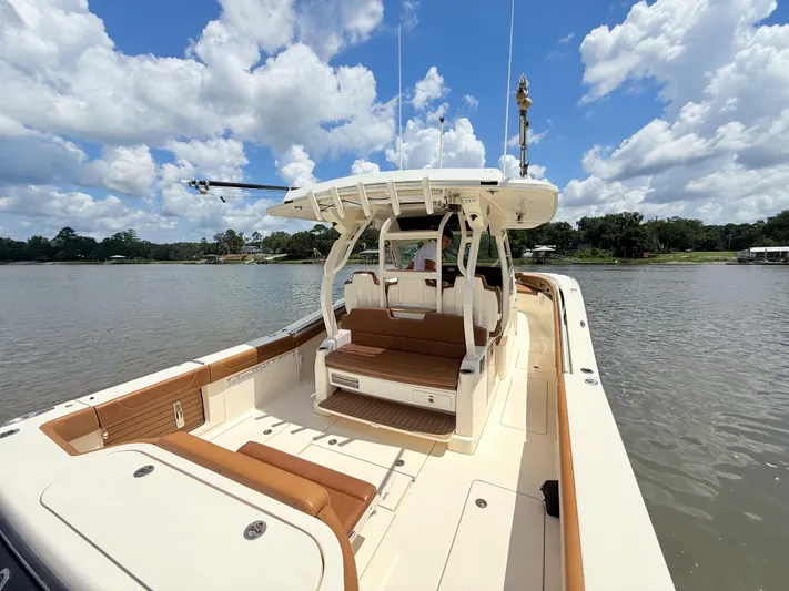 Wild Horses Yacht Photos Pics 2020 Scout 380 LXF boat on a calm lake under a partly cloudy sky.