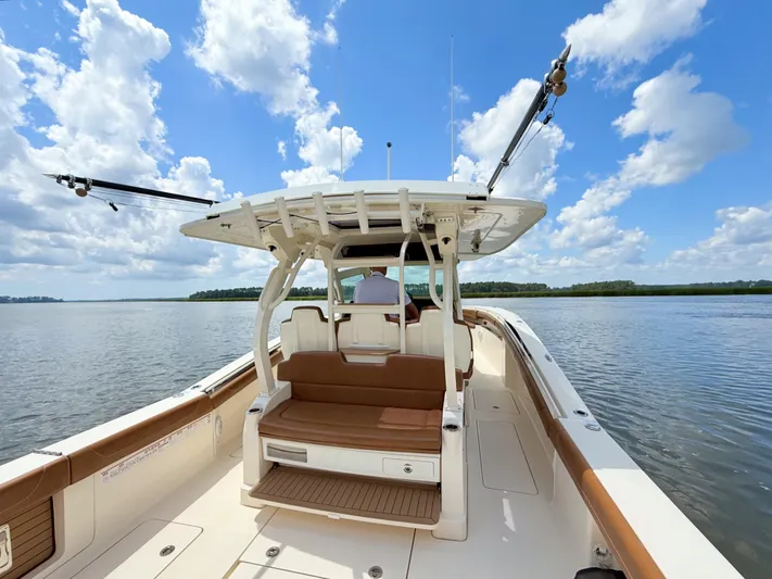 Wild Horses Yacht Photos Pics 2020 Scout 380 LXF boat on calm water under a blue sky with clouds.