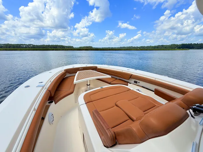 Wild Horses Yacht Photos Pics 2020 Scout 380 LXF boat interior with brown leather seating on a calm lake.