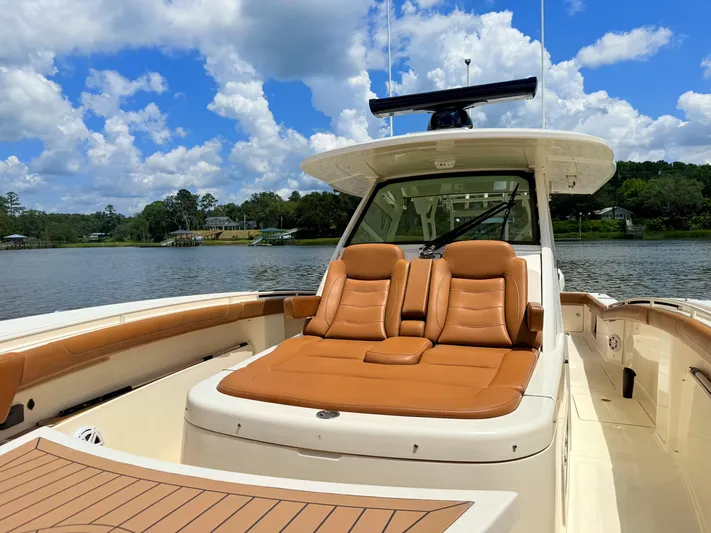 Wild Horses Yacht Photos Pics 2020 Scout 380 LXF boat with tan leather seating, on a scenic lake under a blue sky.