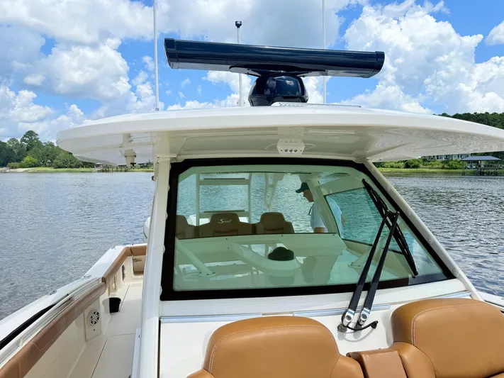 Wild Horses Yacht Photos Pics 2020 Scout 380 LXF boat on calm water with clear sky background.