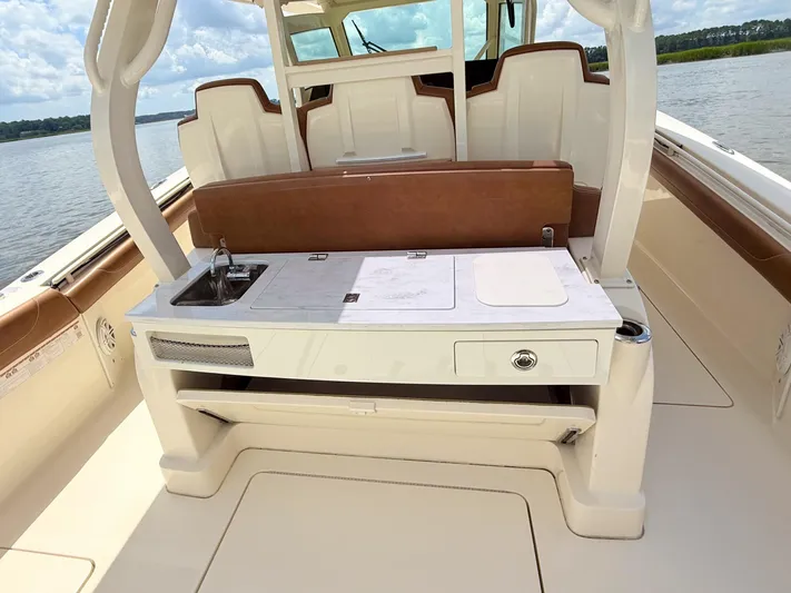 Wild Horses Yacht Photos Pics 2020 Scout 380 LXF boat interior with seating and built-in sink.