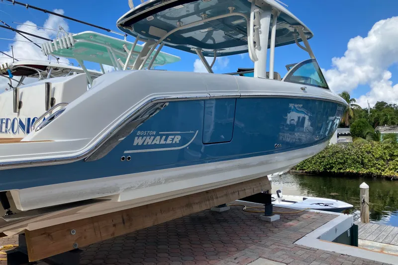  Yacht Photos Pics 2023 Boston Whaler 320 Vantage boat on dock, blue and white design, sunny day.