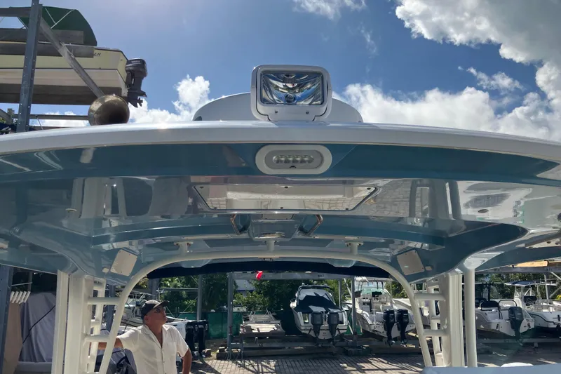  Yacht Photos Pics 2023 Boston Whaler 320 Vantage boat with sleek design and modern features, docked under a sunny sky.