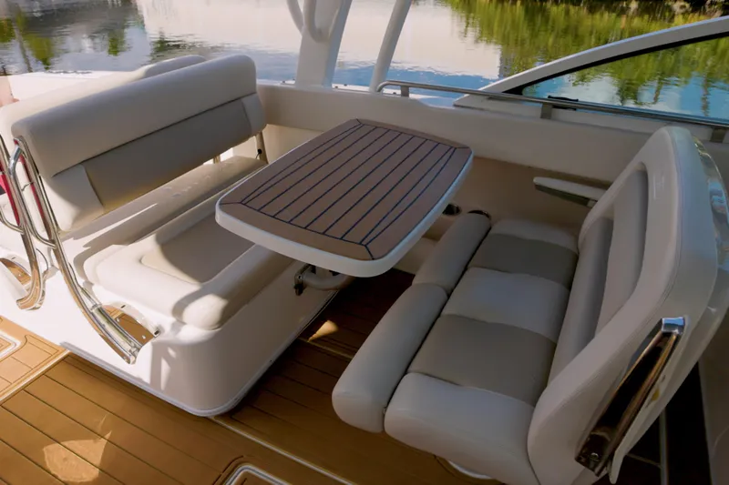  Yacht Photos Pics 2023 Boston Whaler 320 Vantage interior seating with table, featuring elegant design and comfort.