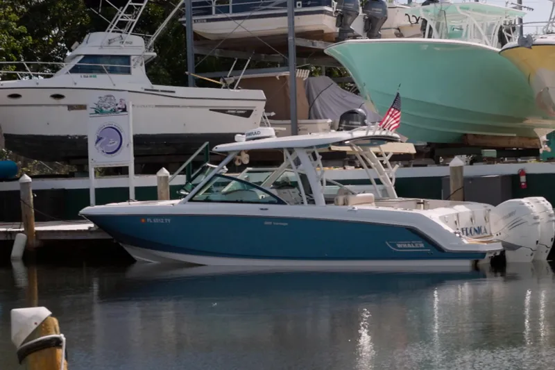  Yacht Photos Pics 2023 Boston Whaler 320 Vantage boat docked at marina with American flag.