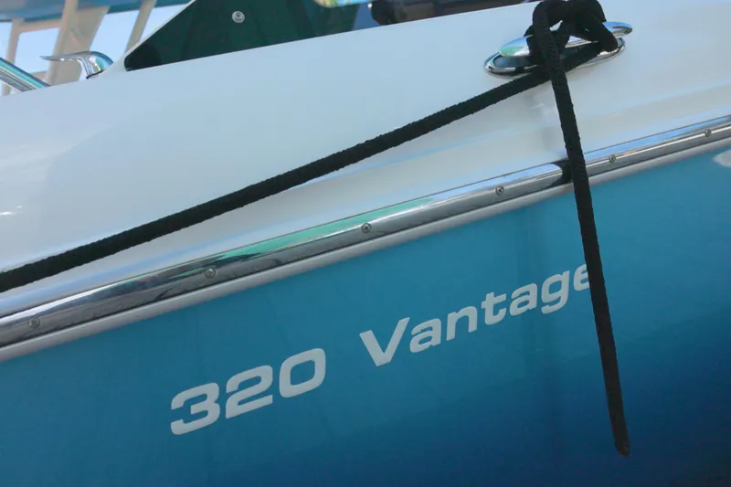  Yacht Photos Pics 2023 Boston Whaler 320 Vantage boat with blue hull and black rope.