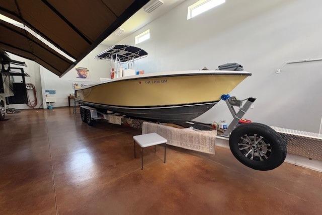 2003 Contender 27 Open boat in indoor storage, on trailer, with yellow hull.