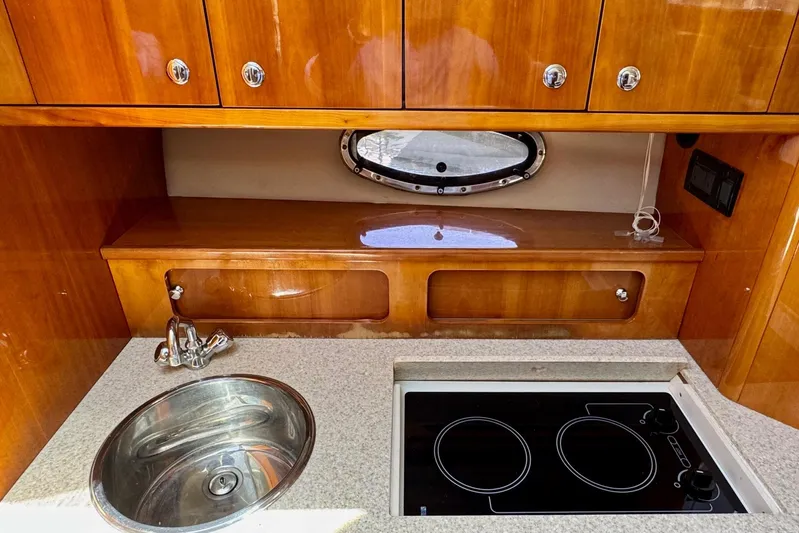 Santa Josefina Yacht Photos Pics 2009 Regal 4080 yacht kitchen with sink, stove, and wooden cabinets.