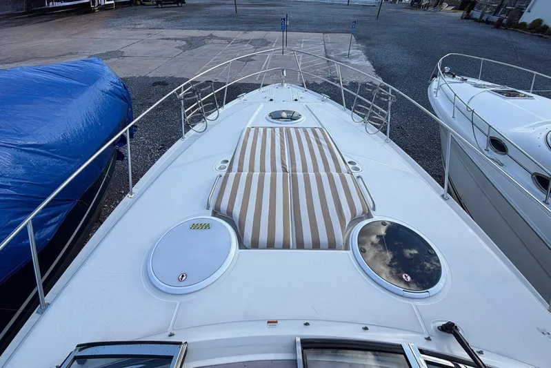 All Too Swell Yacht Photos Pics 2002 Regal Commodore 3860 yacht deck with striped sun pad and circular hatches.