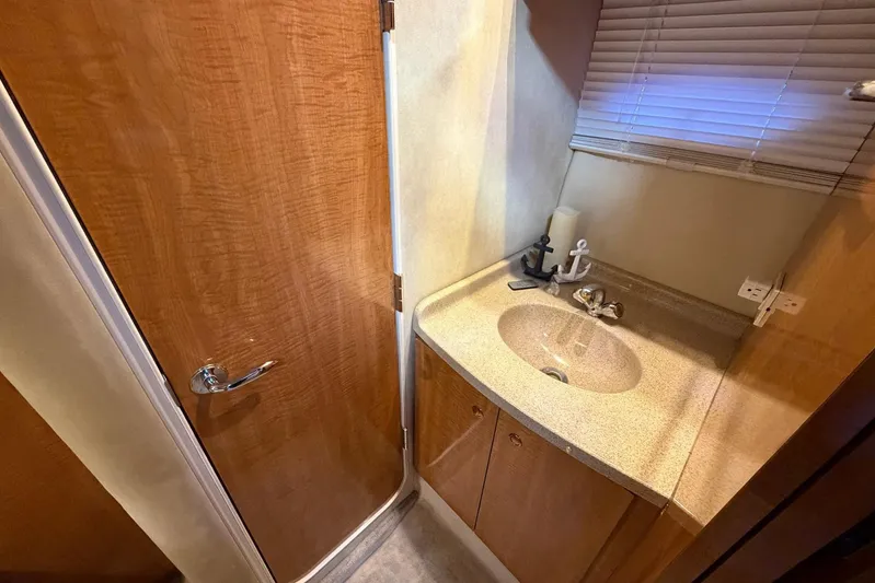All Too Swell Yacht Photos Pics 2002 Regal Commodore 3860 yacht bathroom with wooden door and countertop sink.