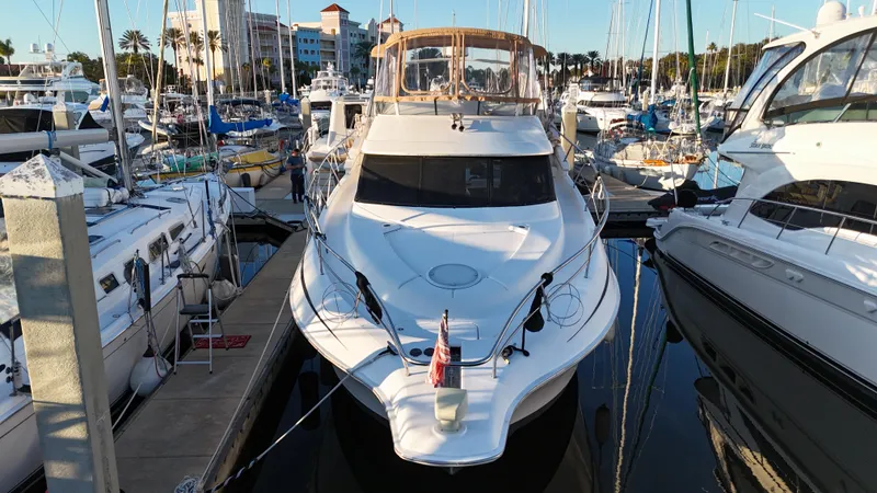  Yacht Photos Pics 2002 Silverton 410 Sport Bridge yacht docked in a marina, surrounded by other boats.