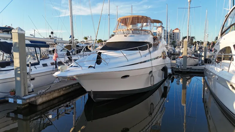  Yacht Photos Pics 2002 Silverton 410 Sport Bridge yacht docked in marina, surrounded by other boats.