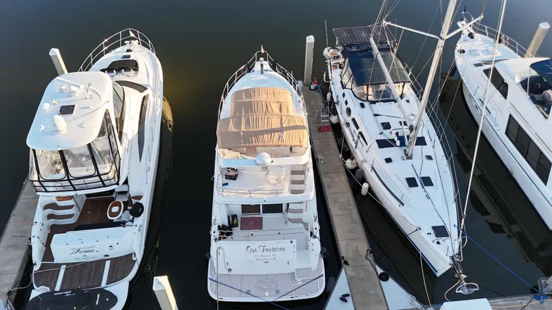  Yacht Photos Pics 2002 Silverton 410 Sport Bridge docked among sailboats and yachts.