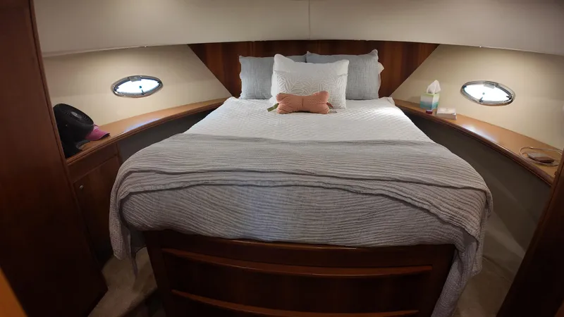  Yacht Photos Pics Cozy bedroom in 2002 Silverton 410 Sport Bridge yacht with porthole windows.