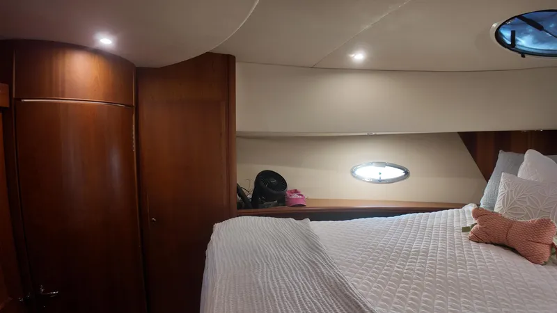  Yacht Photos Pics Interior cabin of 2002 Silverton 410 Sport Bridge with cozy bed and wooden accents.