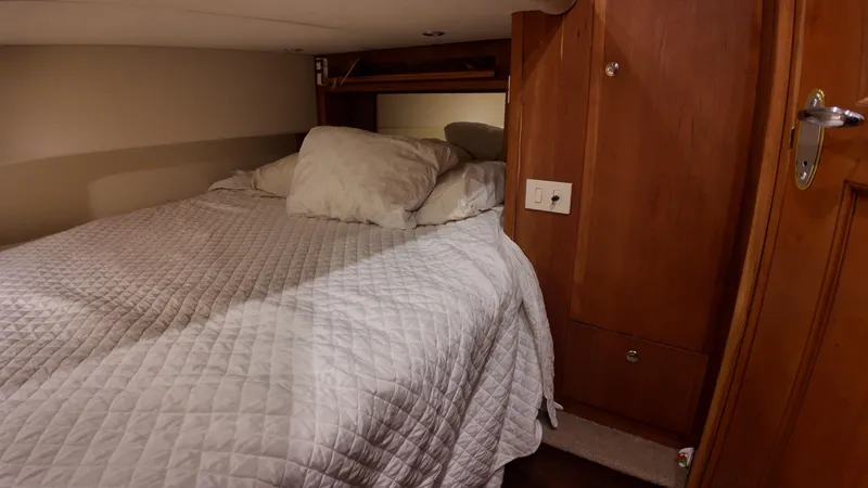  Yacht Photos Pics Cozy bedroom in 2002 Silverton 410 Sport Bridge yacht with wooden cabinetry.